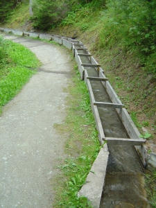 Par endroit, le bisse s'écoule dans un canal en bois.